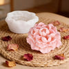 Pink peony flower silicone mold resting on a woven mat with dried rose petals.