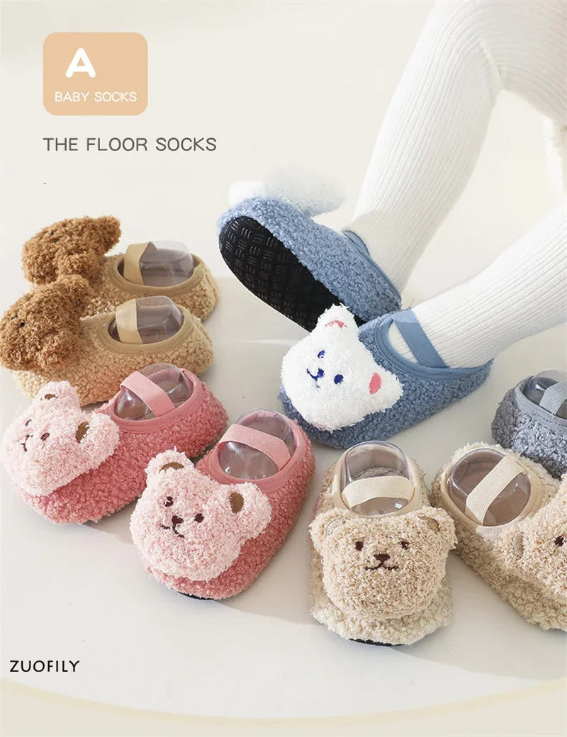 A collection of adorable cartoon bear baby socks and booties in various soft colors like pink, beige, and blue.