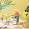 Handmade crochet penguin doll with a positive message card sitting on a white plate.