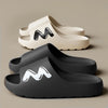 A pair of gray EVA slide slippers with a black zigzag logo on the top
