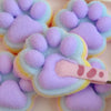 A collection of purple and light blue cat paw shaped mochi squishy fidget toys