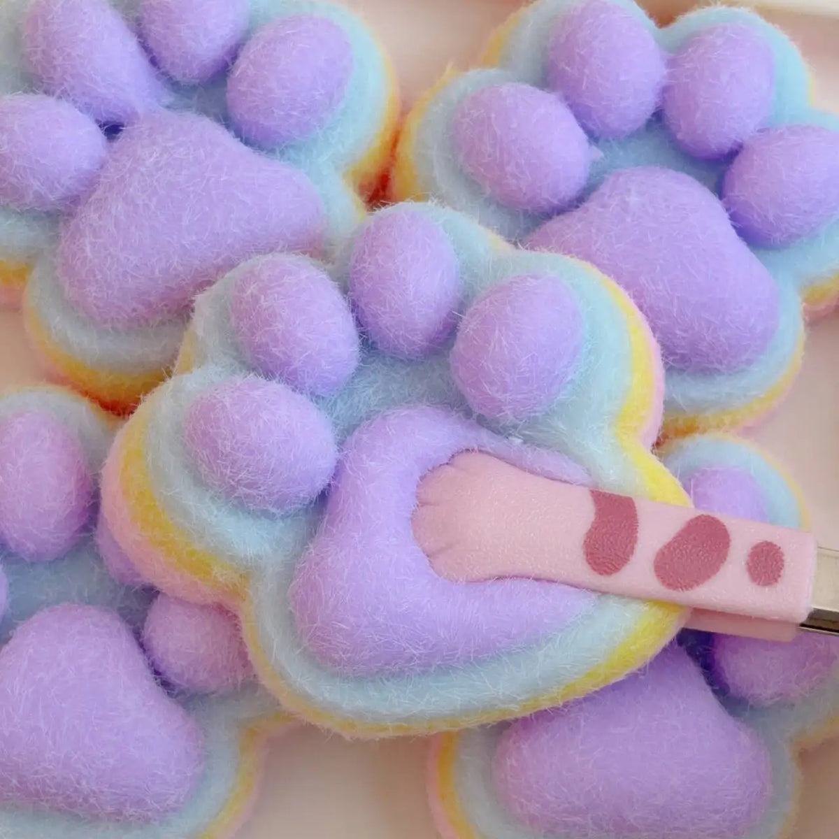 A collection of purple and light blue cat paw shaped mochi squishy fidget toys