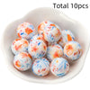 A bowl filled with ten colorful printed silicone beads for DIY jewelry making