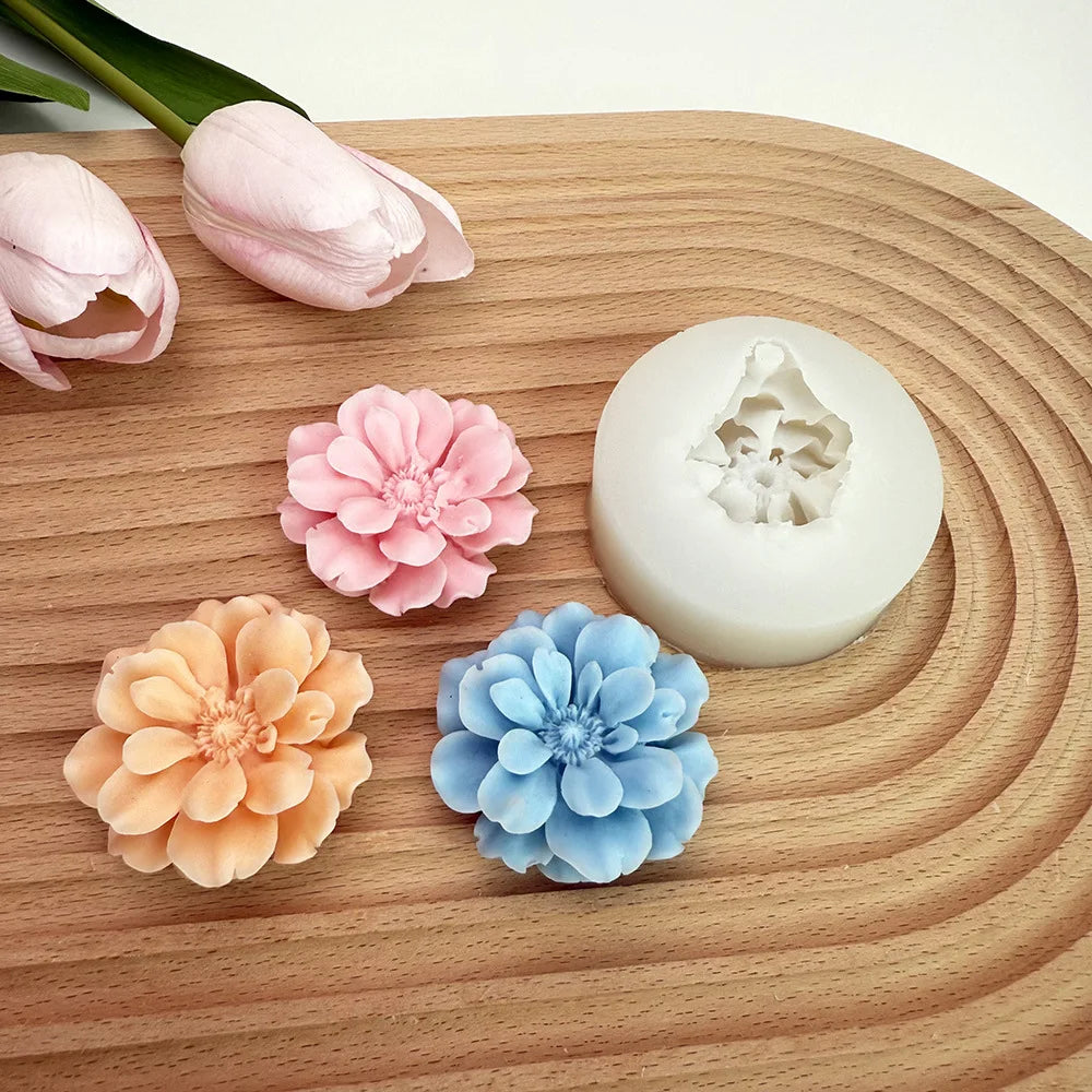 A collection of silicone molds shaped like pink and blue carnation flowers resting on a wooden surface.