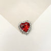 A brilliant red heart-shaped gemstone surrounded by clear rhinestones for DIY crafts.