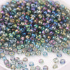 A pile of multicolored glass rice beads in various sizes for DIY jewelry and crafting.
