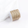 A roll of tan cotton nylon macrame cord for jewelry making and crafts.