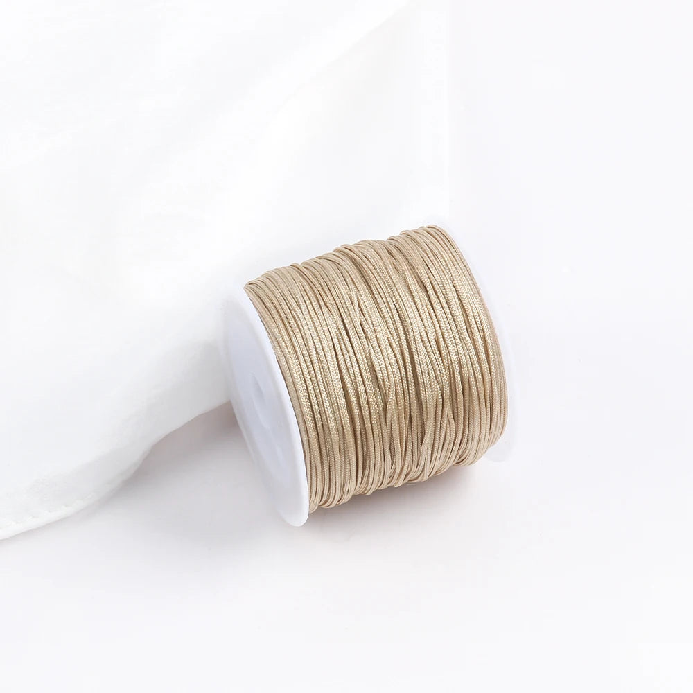 A roll of tan cotton nylon macrame cord for jewelry making and crafts.
