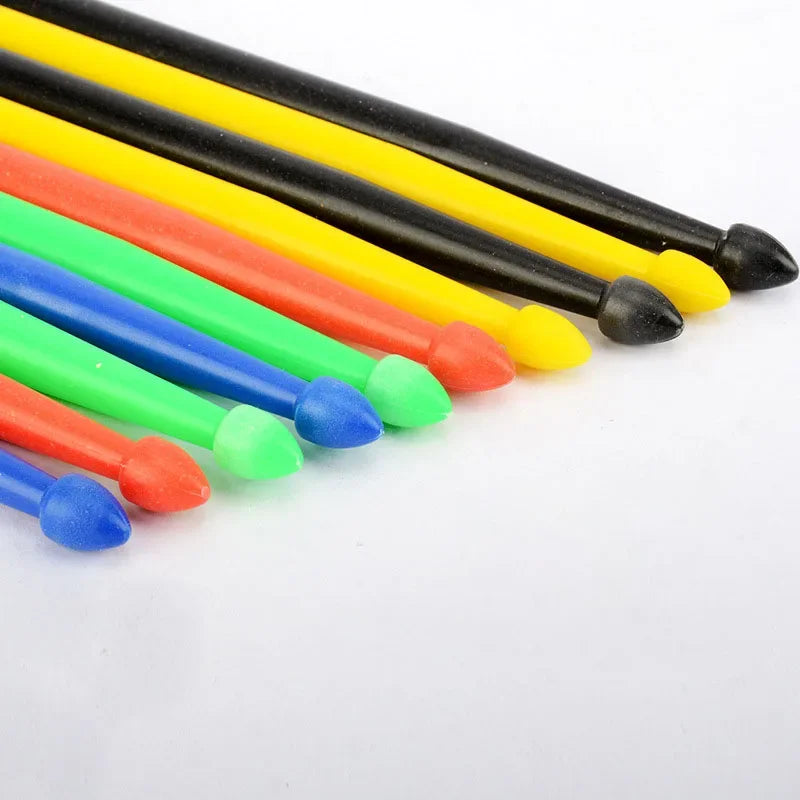 A collection of colorful 5A nylon drumsticks with non-slip grips in various colors like yellow, orange, red, green, and blue.