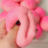 A hand is squeezing a large, pink, squishy stress ball shaped like a snake.