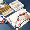 A set of Marie's Chinese painting pigments in tubes is displayed alongside a brush and paper.