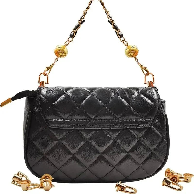 Black quilted leather bag with gold metal D-ring buckle clips hanging from the strap