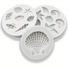 A set of white silicone baking molds shaped like various seashells and sea creatures.