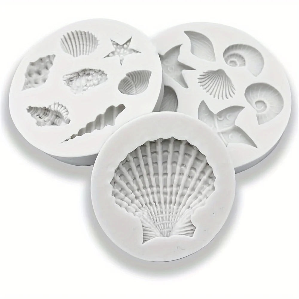 A set of white silicone baking molds shaped like various seashells and sea creatures.