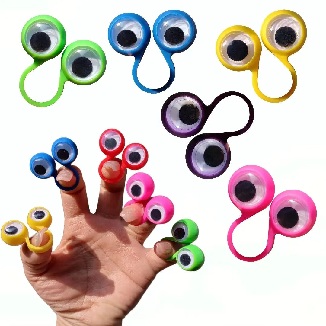 A hand is holding various colorful silicone eye rings, including green, blue, yellow, and purple, for sensory play.