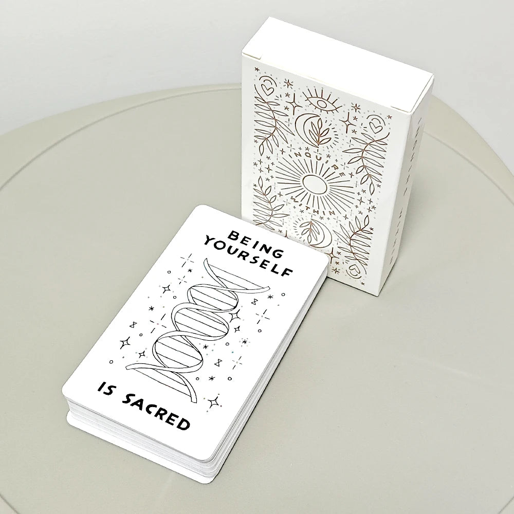A white box of 60 hand-illustrated oracle cards featuring celestial and nature motifs is displayed next to a stack of cards.