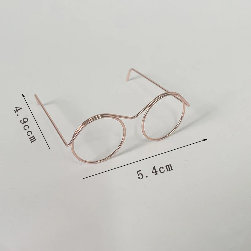 A pair of rose gold metal round glasses frames shown with dimension lines.