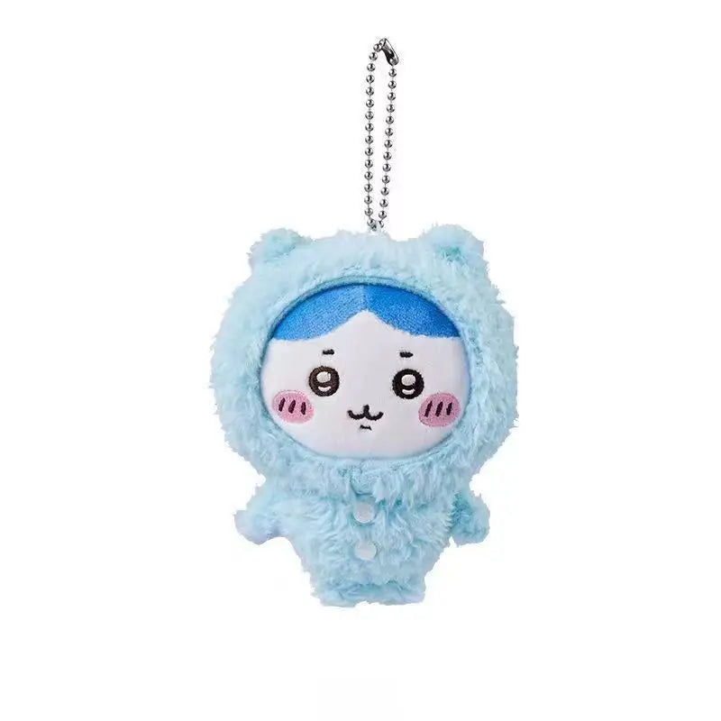 A light blue fluffy plush keychain featuring a face design with blue hair and pink cheeks.