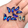 Gold-toned crystal butterfly charm beads displayed on a hand.