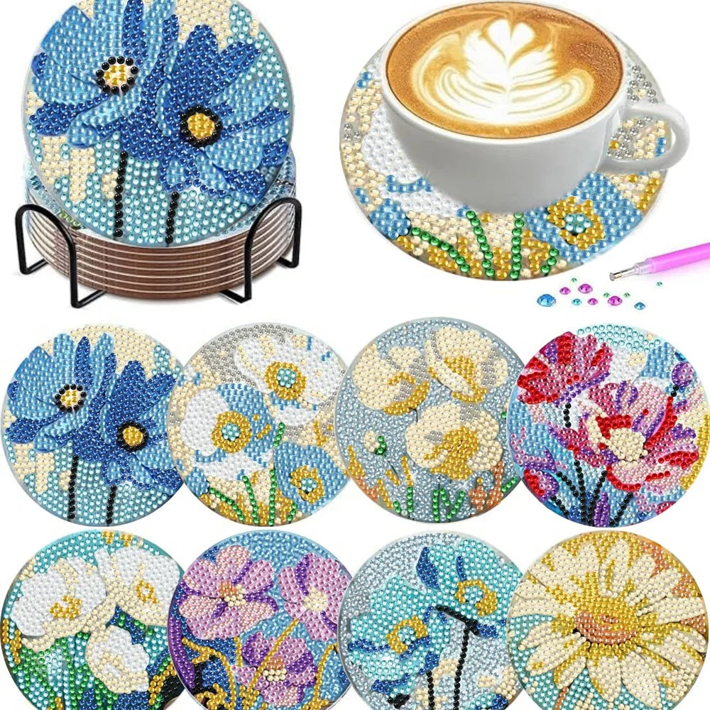 A set of floral diamond painting coasters featuring blue, yellow, and pink flowers with a metal holder.