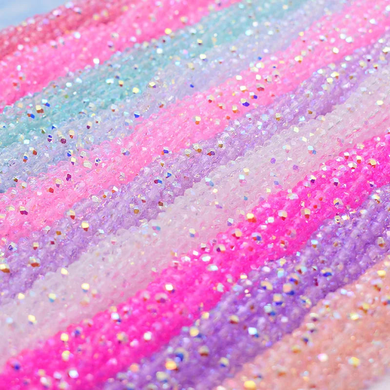 Close-up of iridescent pink and purple faceted crystal rondelle beads with glitter accents
