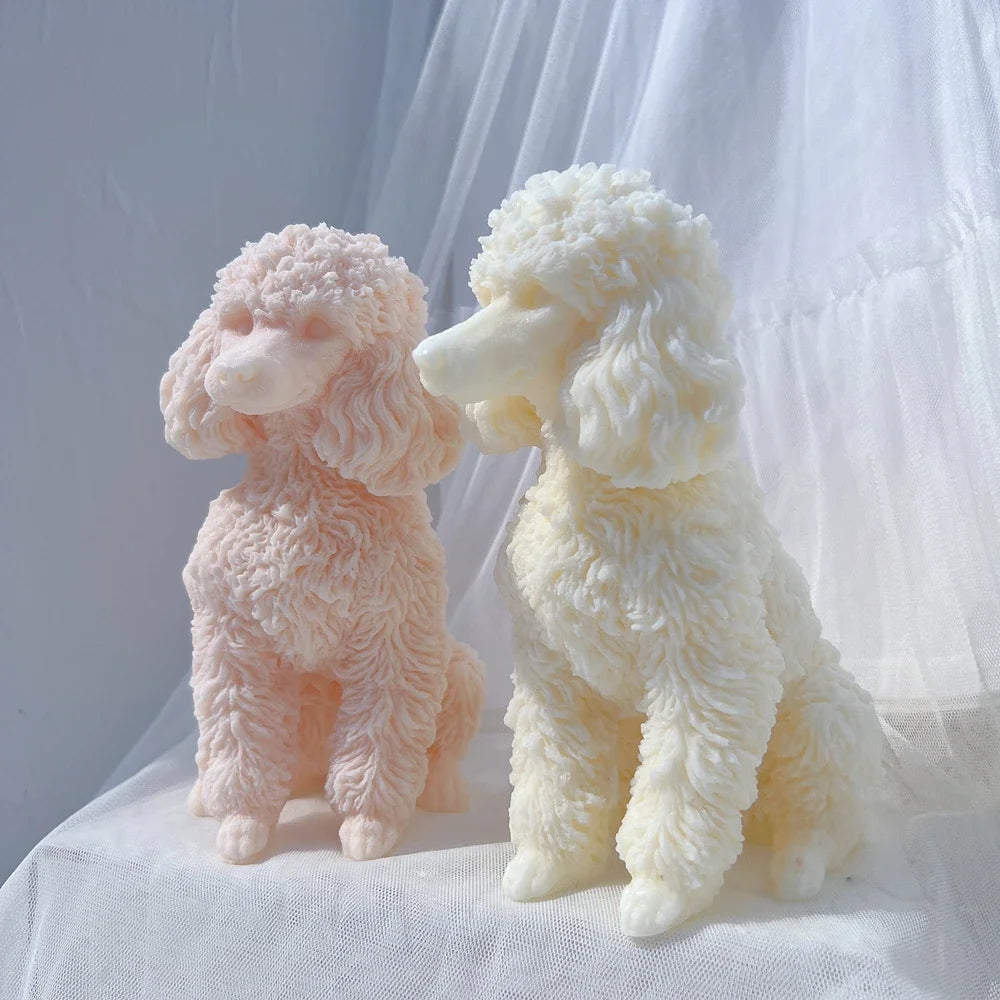 Two fluffy poodle dog silicone candle molds in pink and cream colors sitting on white fabric