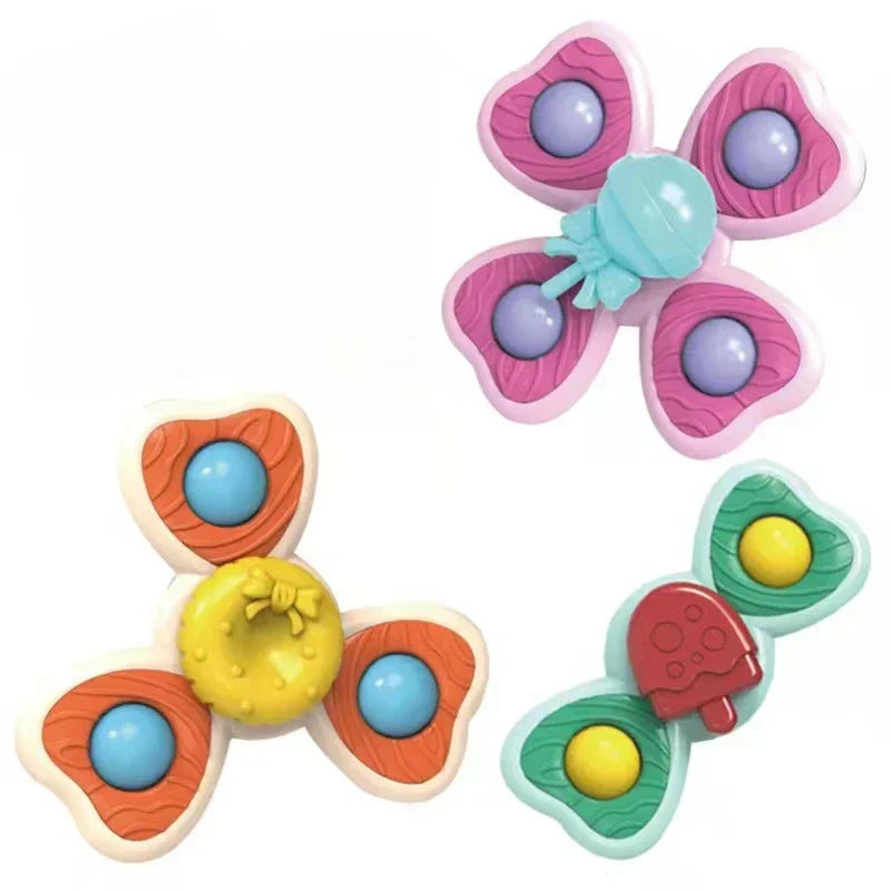 A three-piece set of suction cup spinner bath toys for babies featuring pink and green plastic with colorful spheres.