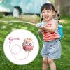 A young girl is playing with an animal backpack water gun toy outdoors.