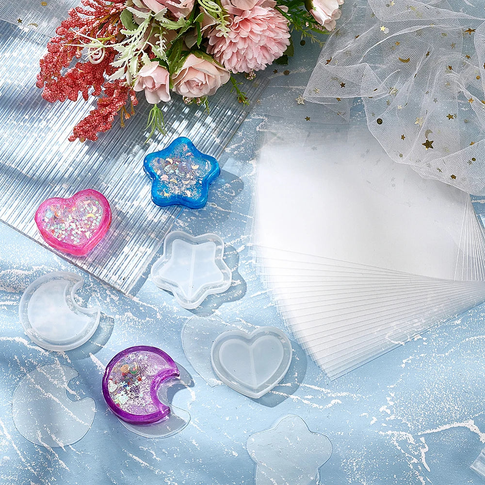 Silicone shaker molds with protective sealing sheets for DIY jewelry displayed on a blue surface.