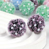 A close-up of purple rose flower ball acrylic beads for jewelry making resting on a white surface.