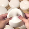 Hands holding a white yogurt cake squishy stress relief toy with silver glitter accents