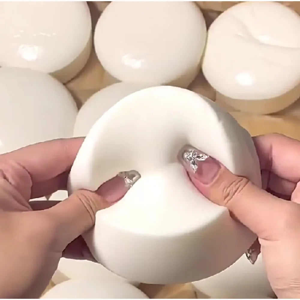 Hands holding a white yogurt cake squishy stress relief toy with silver glitter accents