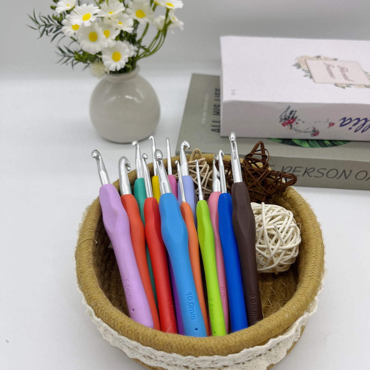 A set of ergonomic crochet hooks, stitch markers, and needles in various colors stored in a natural fiber basket.
