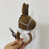 A handcrafted wooden baby rattle and teether ring shaped like a brown donkey or horse.