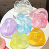 A collection of translucent, shapeable silicone fidget balls in various colors including pink, blue, purple, and yellow.
