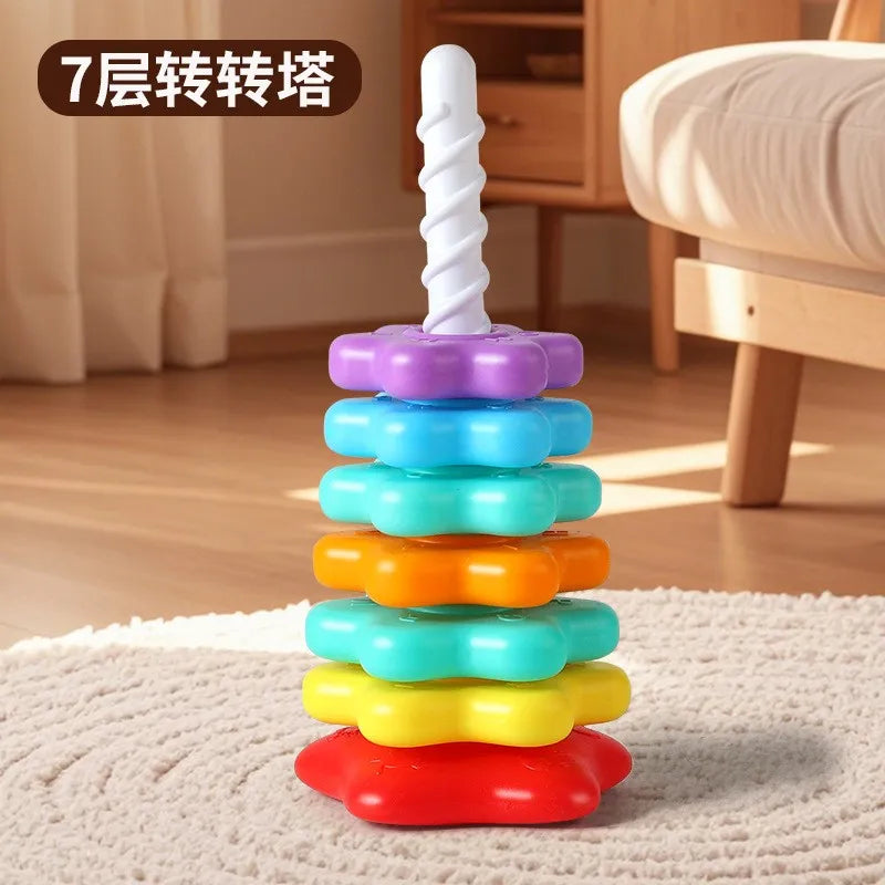 A colorful rainbow stacking tower toy made of plastic rings and a white spire for toddlers.