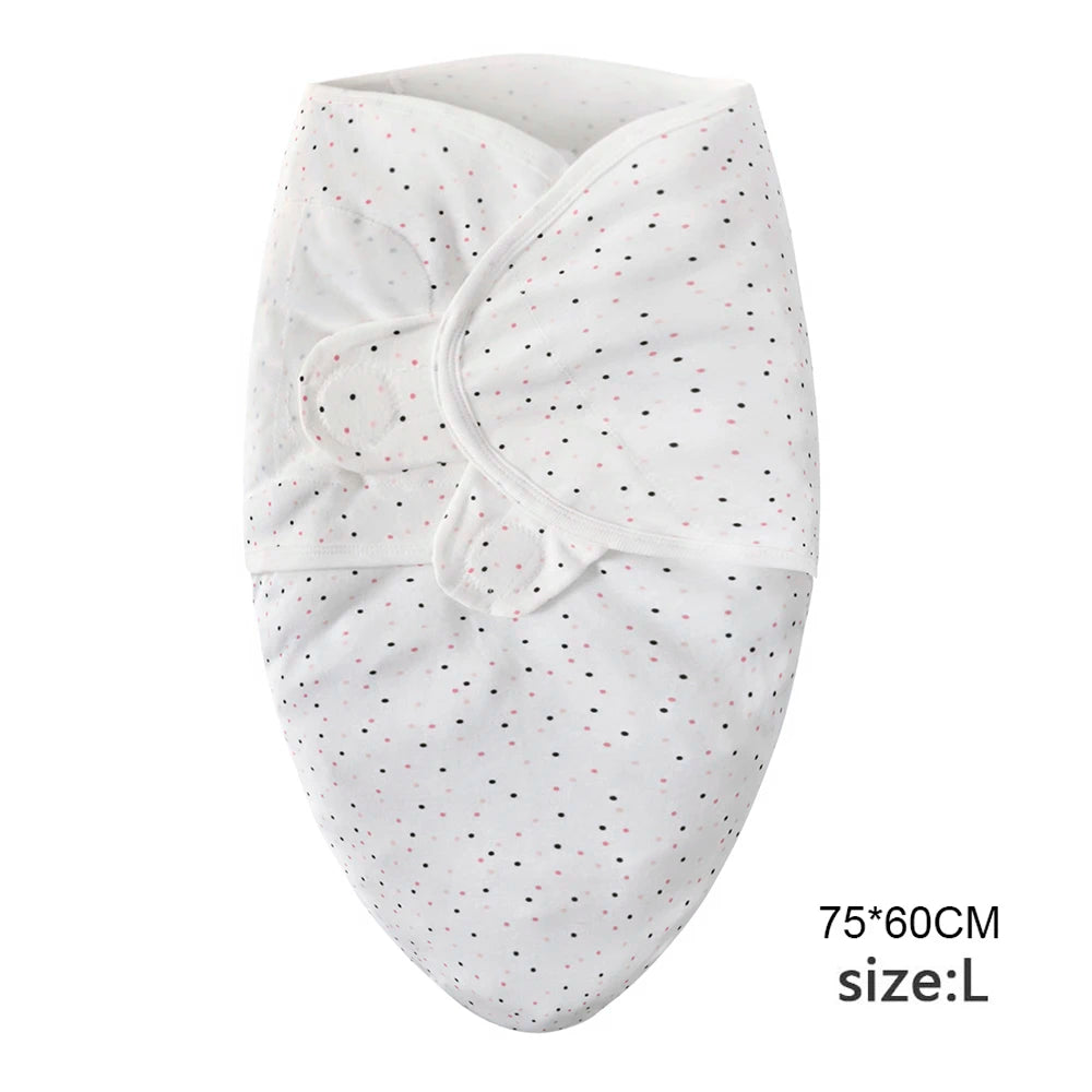 White cotton newborn swaddle blanket and hat set with small black and pink dots