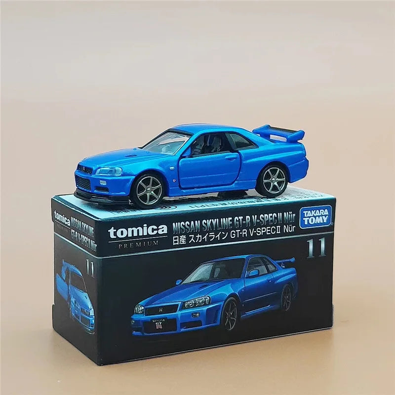 A blue Nissan Skyline GT-R model car in a box, featuring a rear spoiler and wheels.