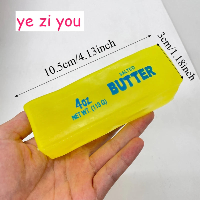 A yellow salted butter stick is held in a hand, showing its size and weight measurements.