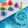 A colorful water-squirting turtle bath toy with a fishing net is shown floating in blue water.