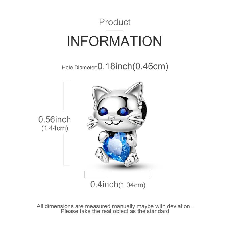 A silver heart charm shaped like a cat's face with blue eyes and a sparkling blue gemstone.