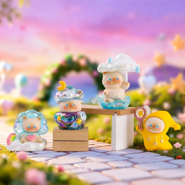 Sammlung von niedlichen Wetterkatzen-Figuren in Pastellfarben auf einem Holzständer im Freien.