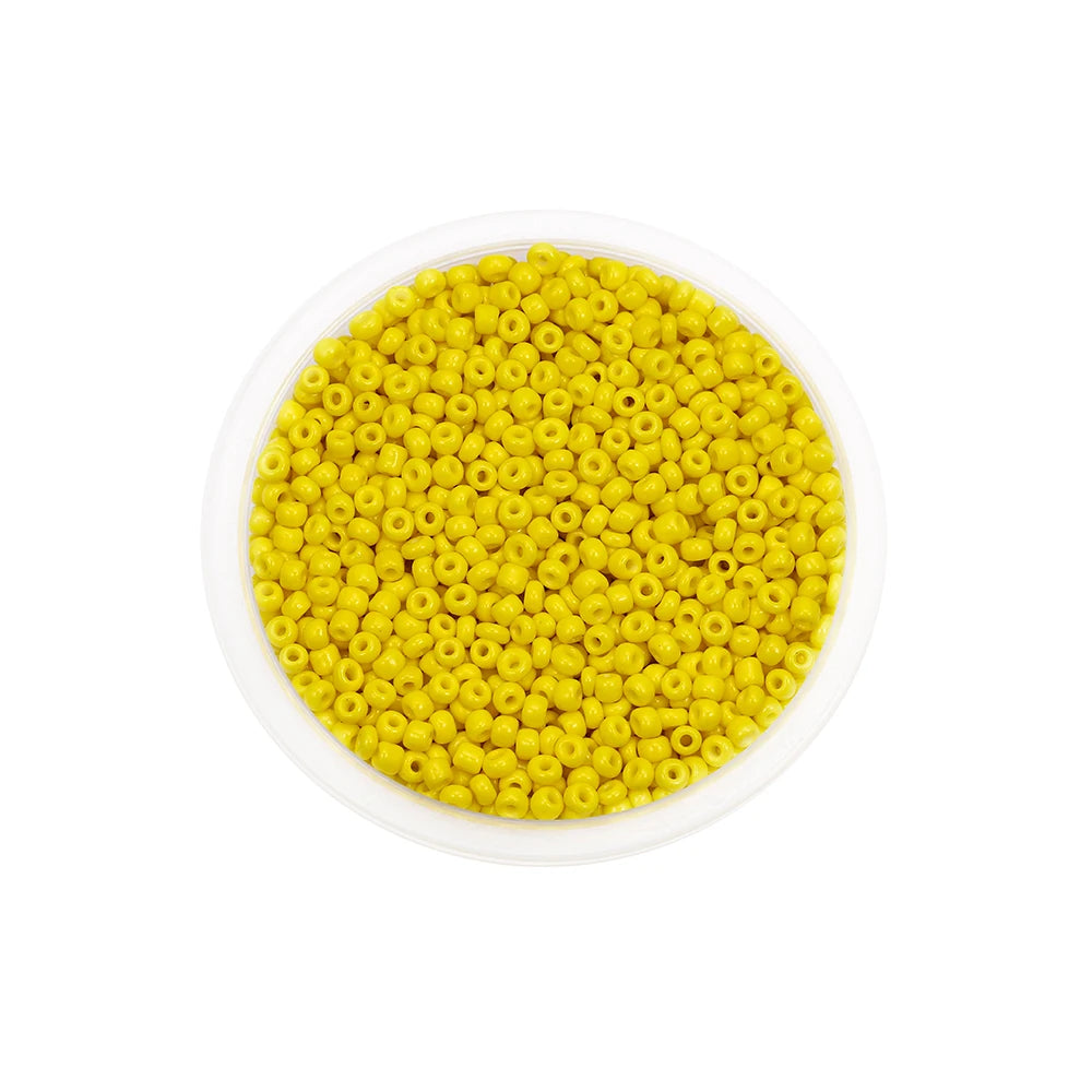 A circular plastic container filled with bright yellow Czech glass seed beads for jewelry making