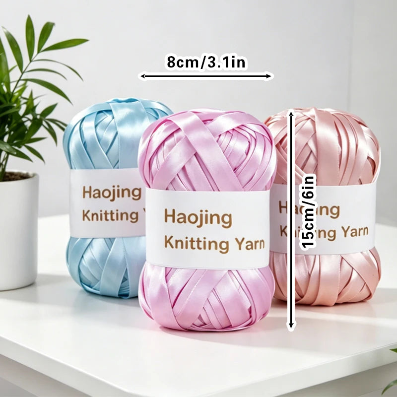 A set of nine colored satin ribbon knitting yarn skeins displayed on a white surface.