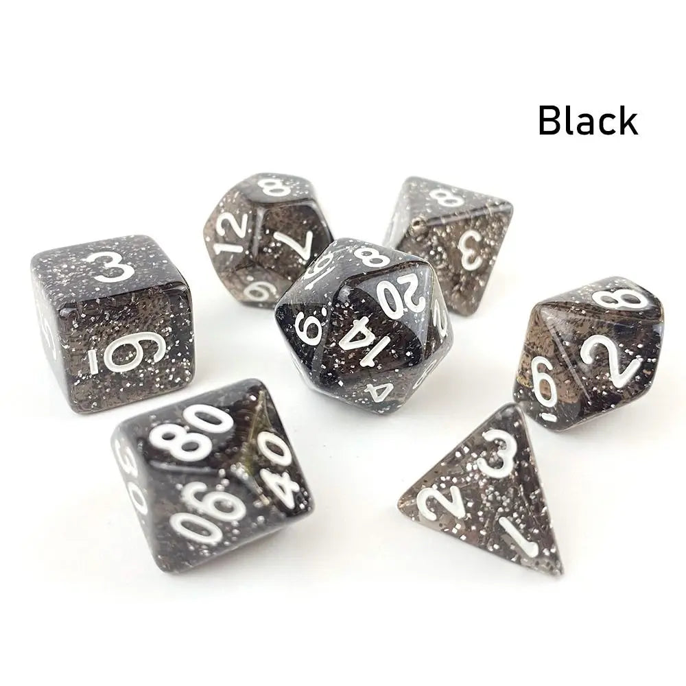 A set of seven black polyhedral acrylic dice, including d6s and d10s, scattered on a white surface.