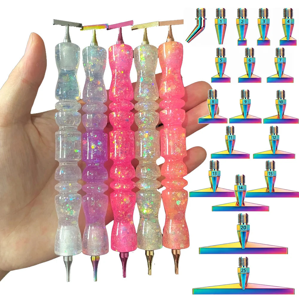 A hand holds a set of diamond painting pens with interchangeable resin tips in various colors and sizes.