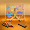 An LED acrylic message board displays neon signals and a welcome message with 7 colored pens in front of it.