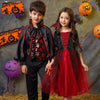 Two children dressed in vampire bat costumes with capes and accessories posing against a textured background.