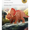 A detailed model of a Triceratops dinosaur, featuring reddish-brown skin and horns, displayed on a dark rock.