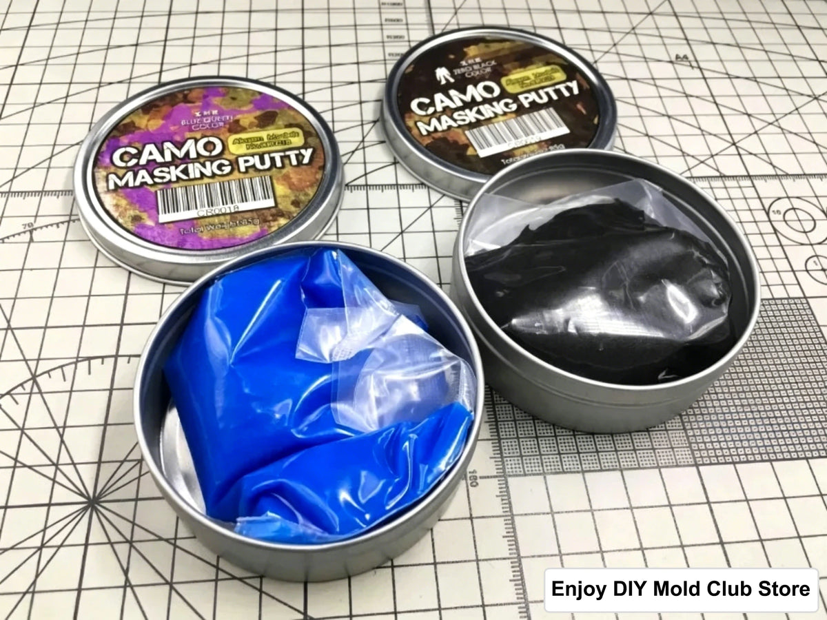 A collection of Camo Masking Putty in tins and a jar of blue putty on a grid background.